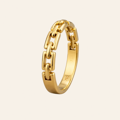 A polished yellow gold ring with a modern geometric link design, standing upright on a neutral light gray background.