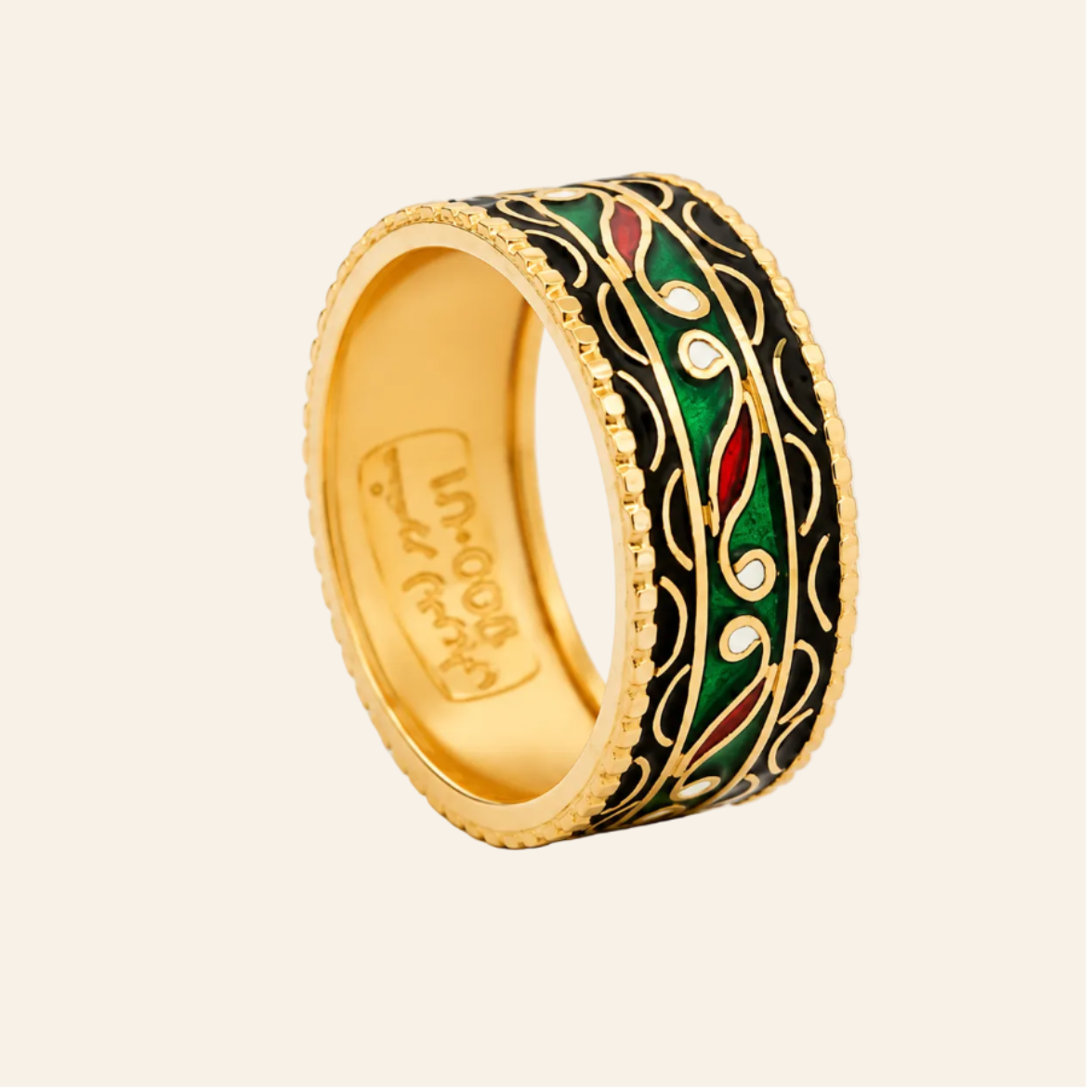 A gold-plated ring with a black enamel background and intricate green, red, and white floral enameled details, shown on a clean white background.